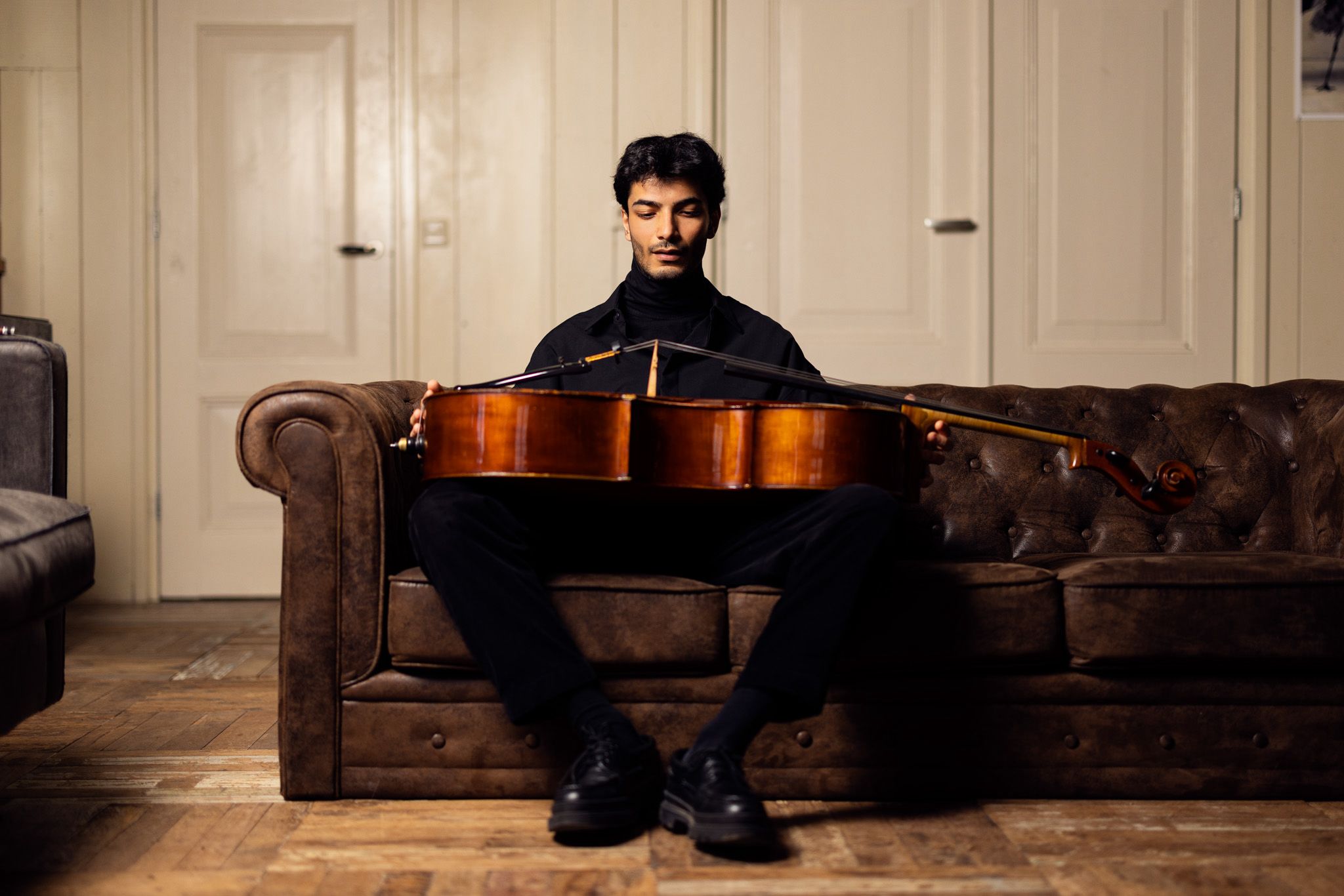 Yunus Altıkanat holding his cello across his lap